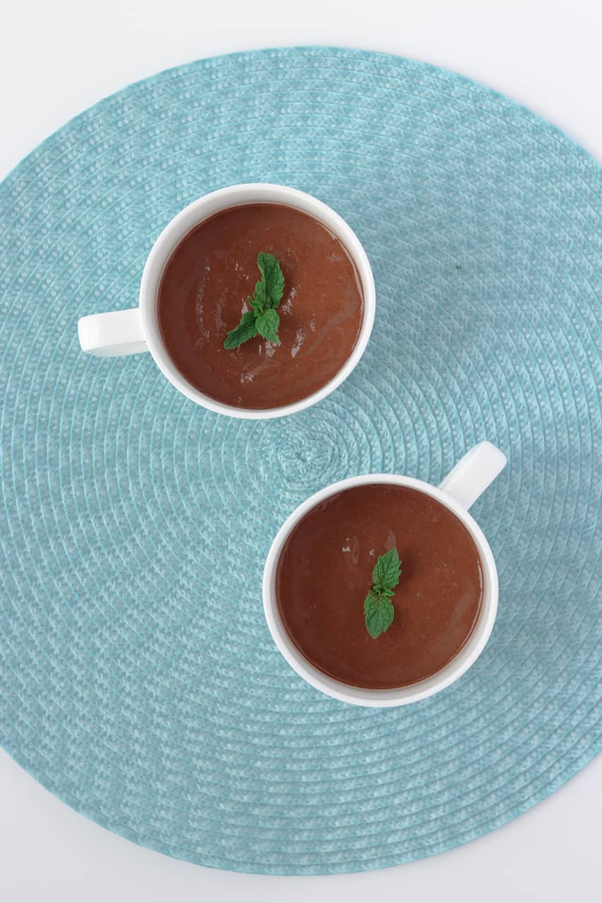 skinny chocolate mint chia powder pudding in 2 white china mugs on a turquoise placemat