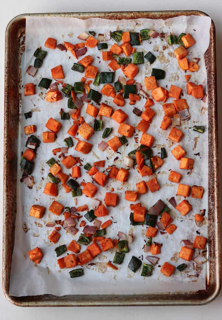 sheet pan with diced sweet potatoes, red onion, poblano peppers and red onions