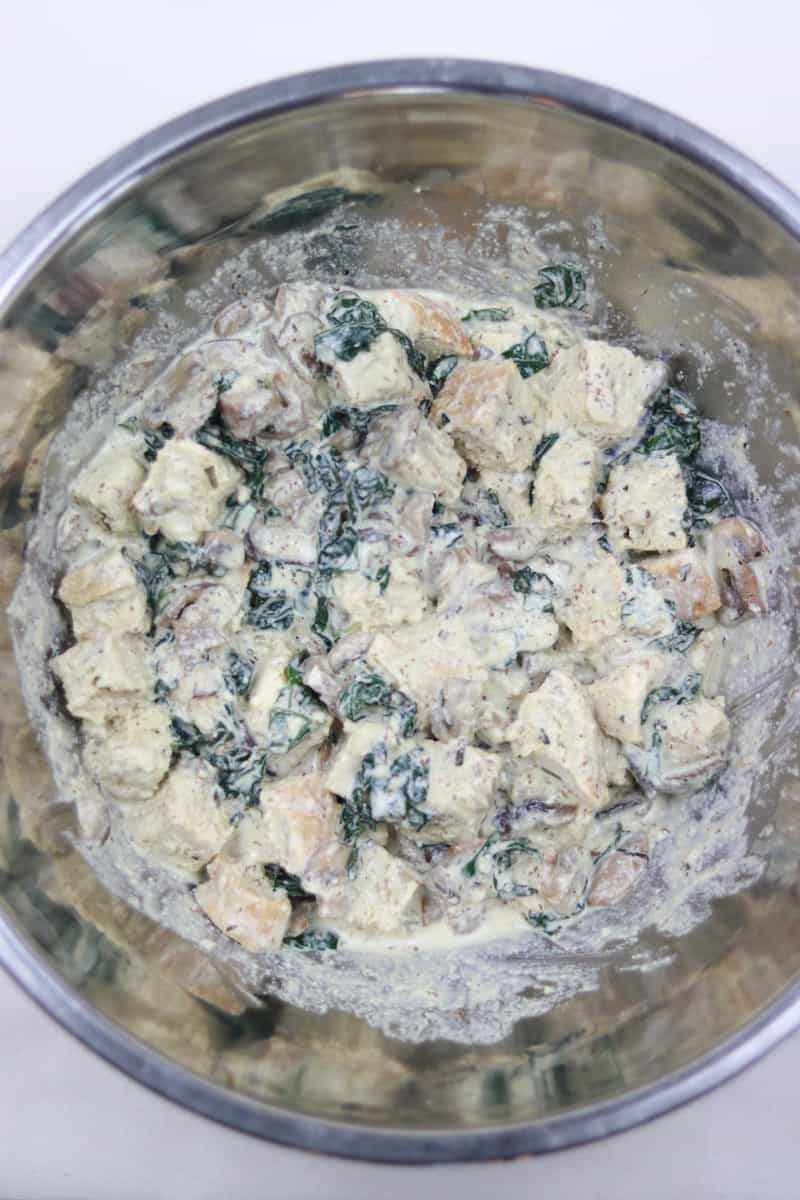 Kale Mushroom Bread Pudding ingredients in a large metal mixing bowl.