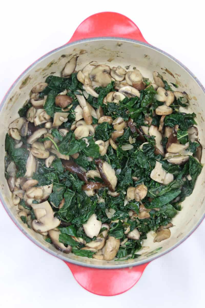 Kale and Mushrooms sautéed in a red dutch oven.