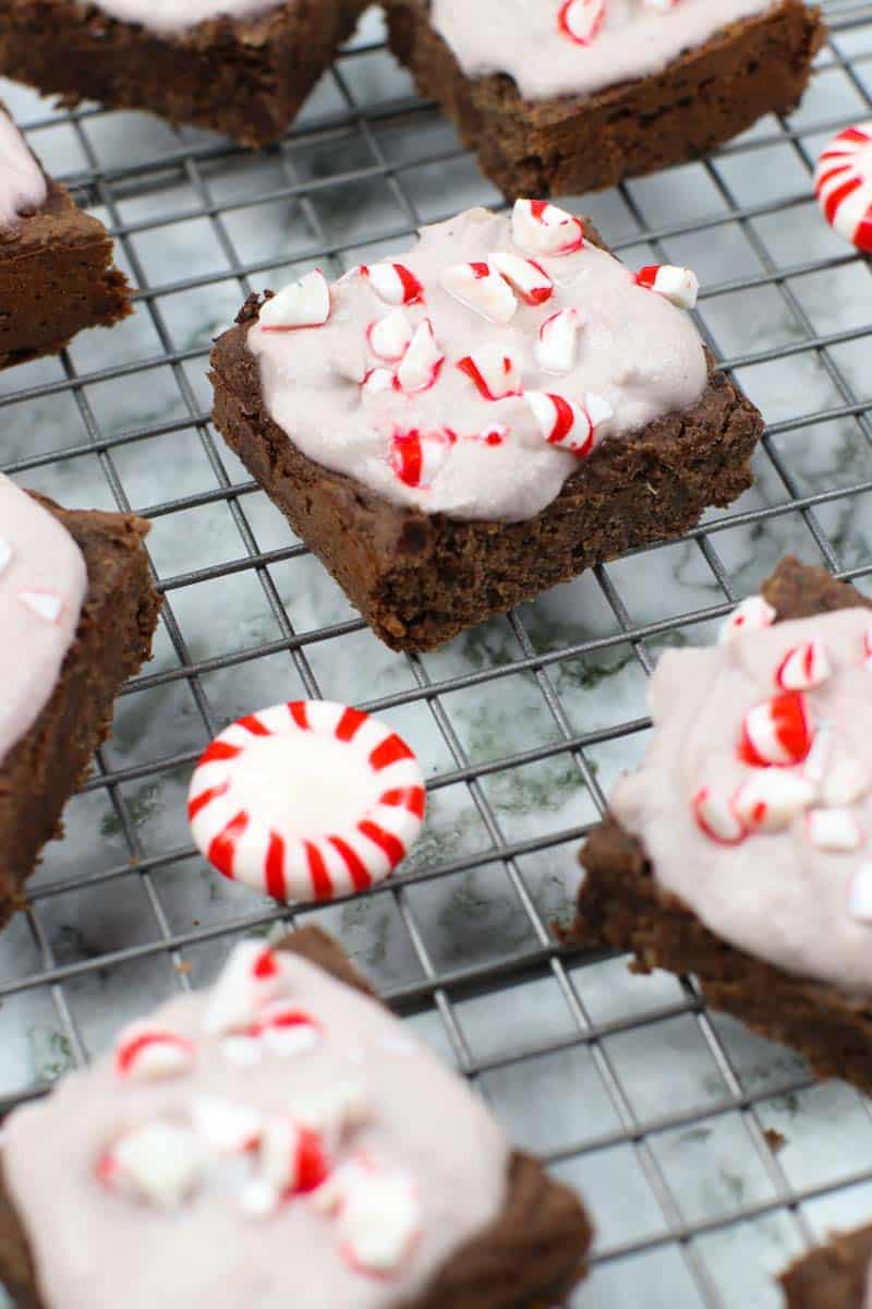 Healthy Brownies With Peppermint Frosting on a cooling rack with peppermint candies