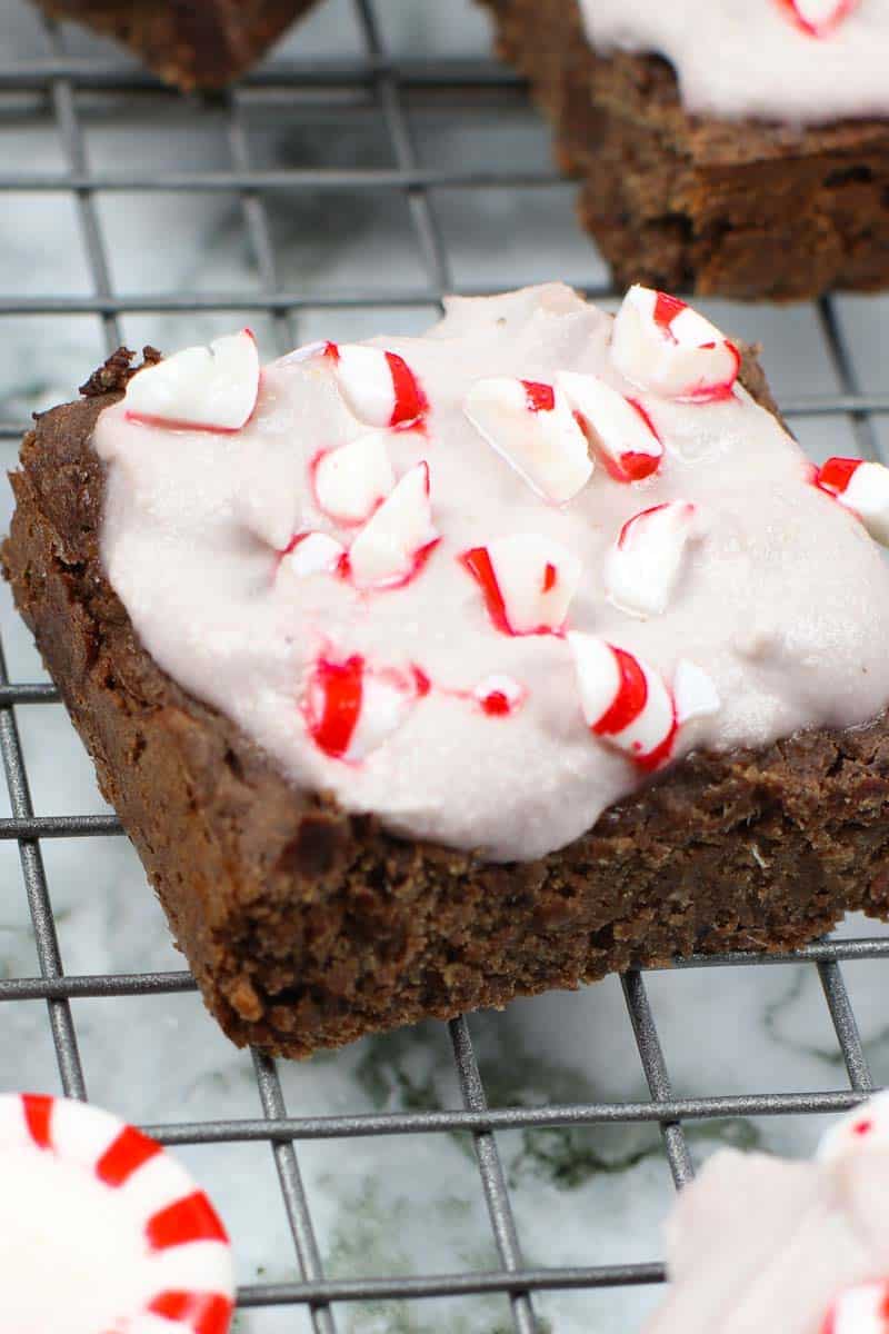 close up of Healthy Brownies With Peppermint Frosting on a cooling rack with peppermint candies