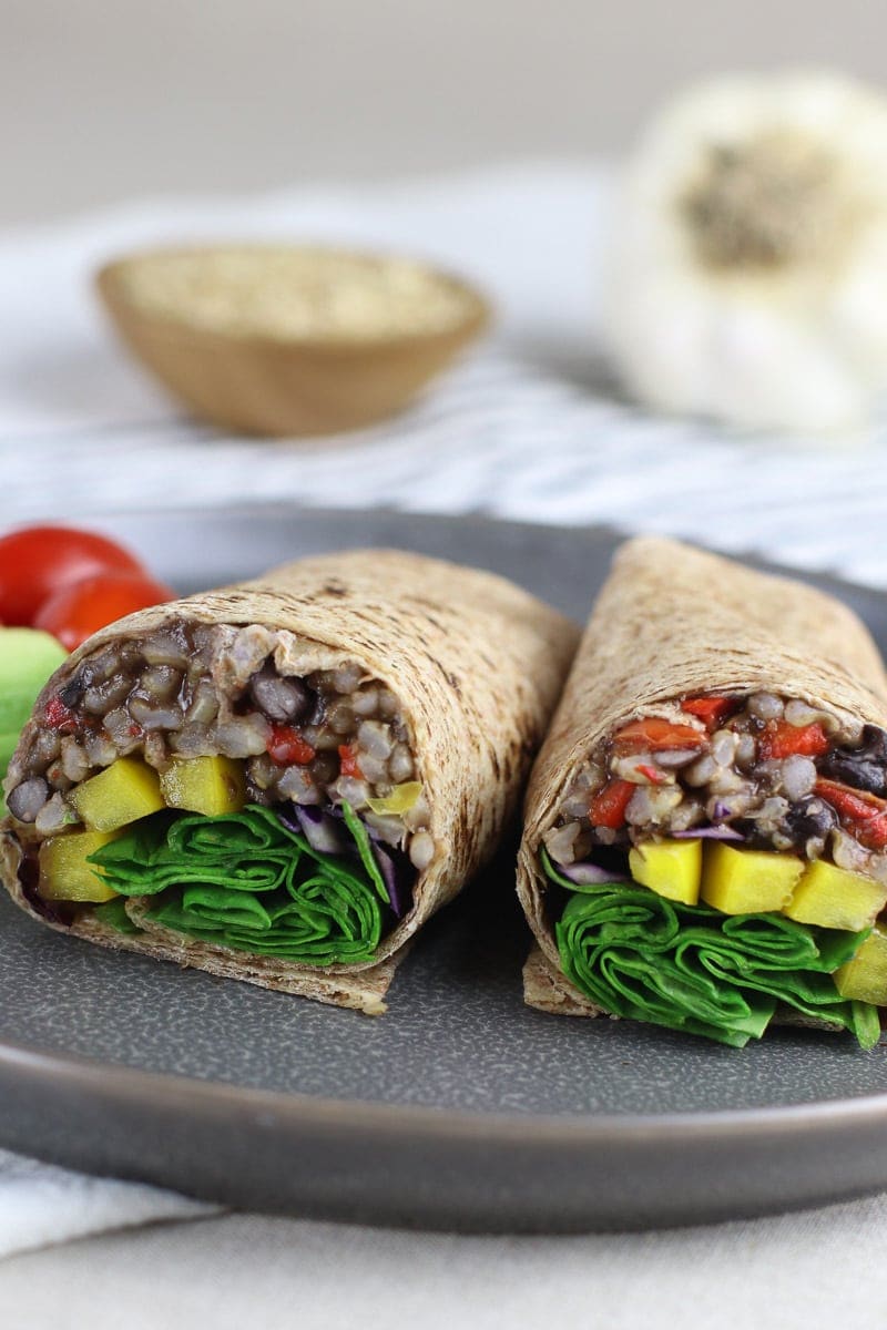 Smoky Black Beans & Rice Wrap with yellow peppers and spinach sandwich on a gray plate