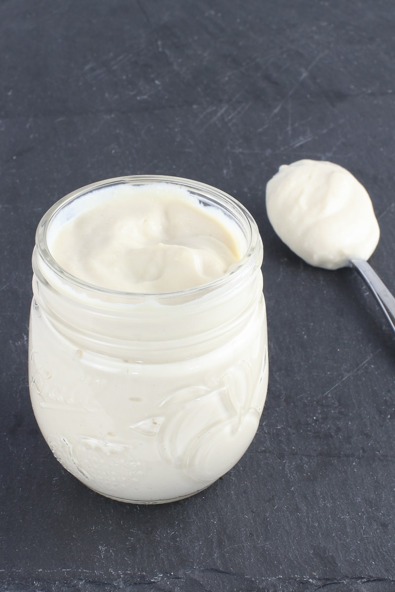 vegan oil free mayo in a jar with a spoon on a black background