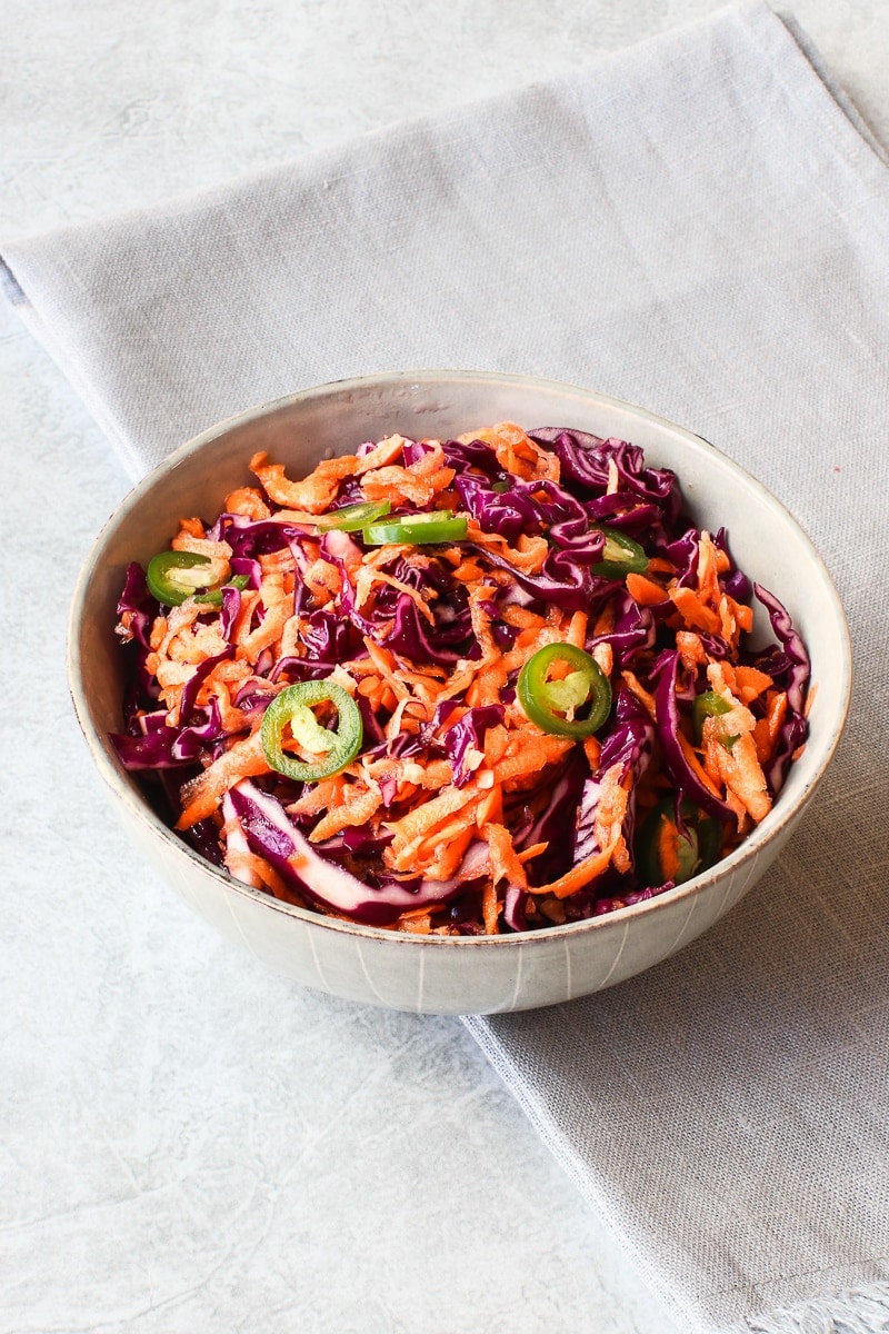 bowl of purple cabbage slaw with carrots and jalapeños