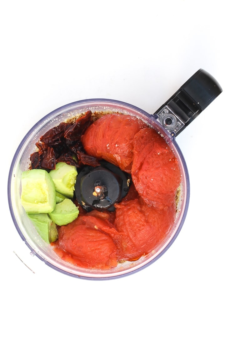 tomatoes, avocado, almonds, garlic and peppers in a food processor