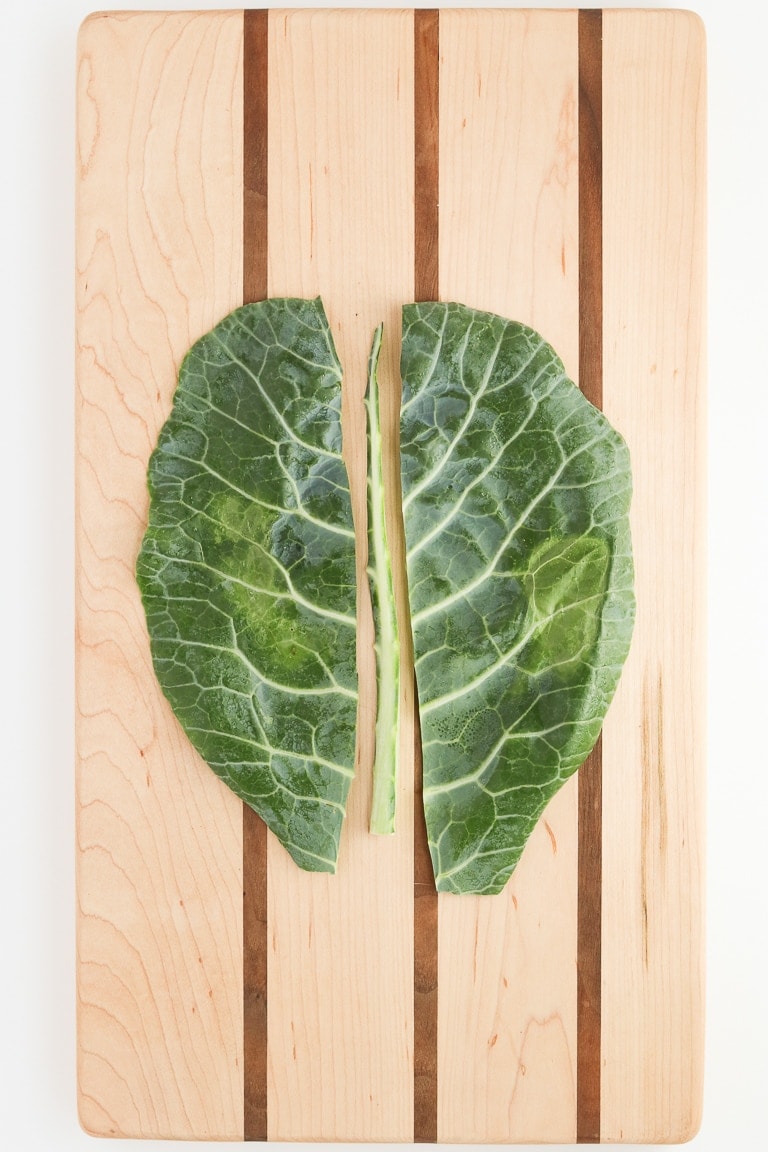 collard green leaf with center stem cut out on a cutting board