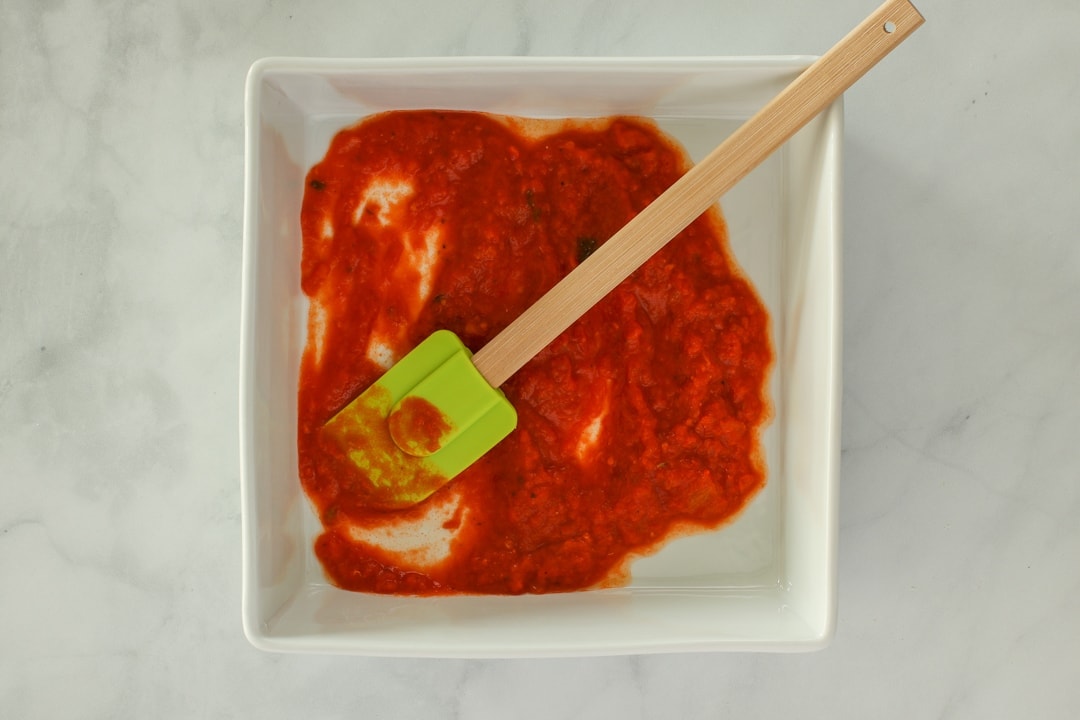Coat the bottom of a baking dish with tomato sauce. 