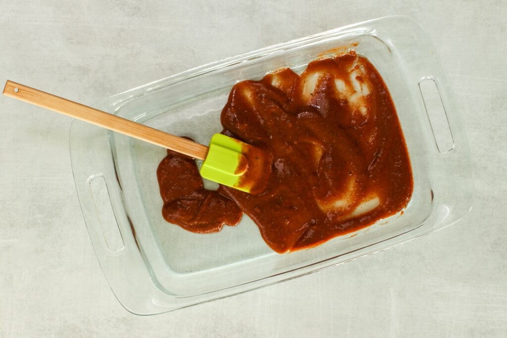 Spread some enchilada sauce in the bottom of a baking dish.