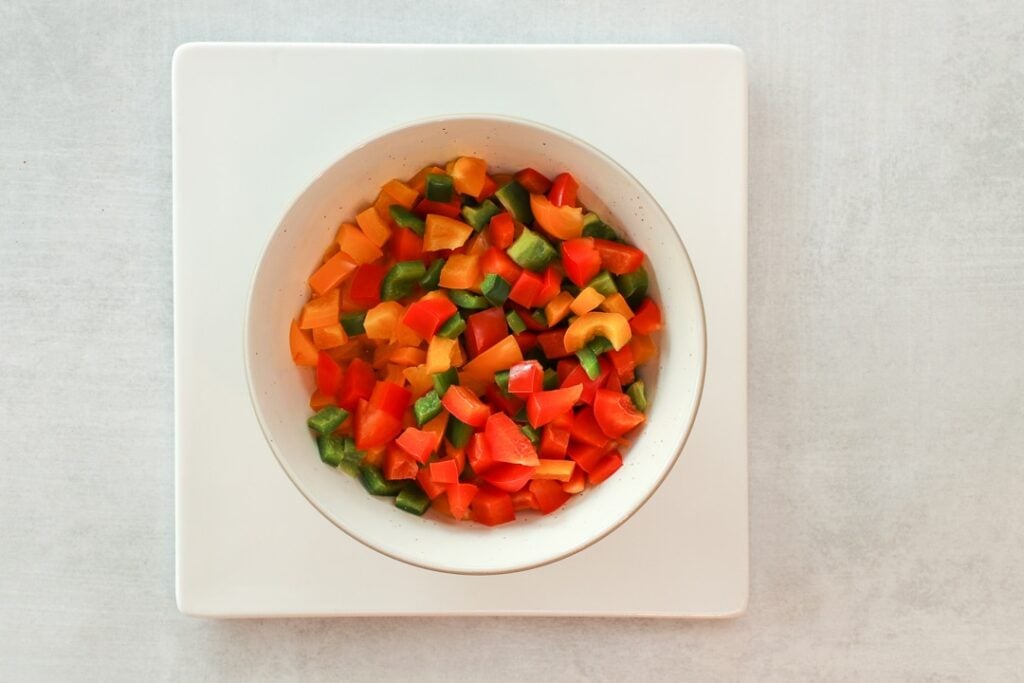 Diced peppers in a white bowl.