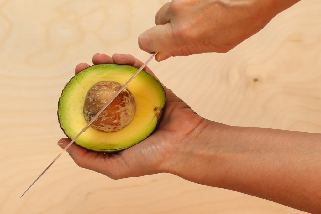 Inserting my knife blade into the avocado pit. 