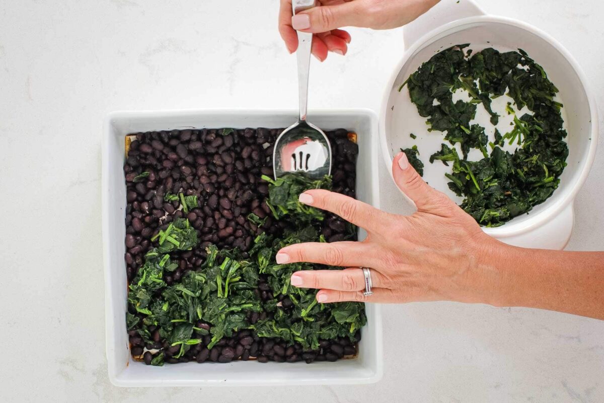 spooning spinach into the dish