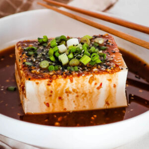 Close up of tofu with spicy soy dressing.