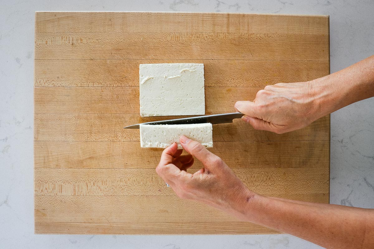 Cutting tofu with a knife.