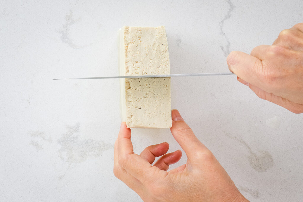 Cutting tofu blocking half. 