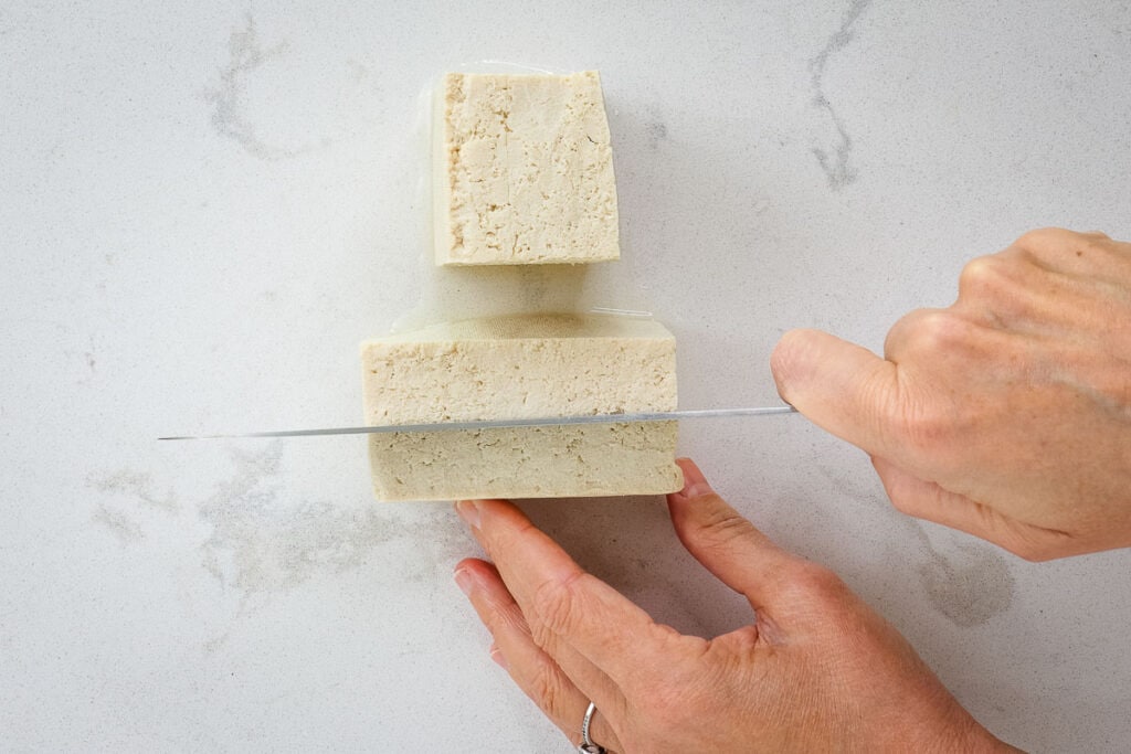 Cutting tofu block into quarters. 
