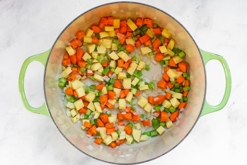 Diced vegetables in a Dutch oven.