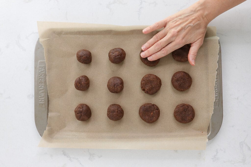 Twelve balls on a baking sheet, pressing one down with my fingers. 
