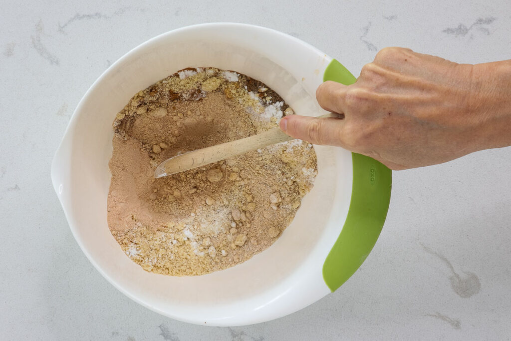Stirring dry ingredients with a wooden spoon.