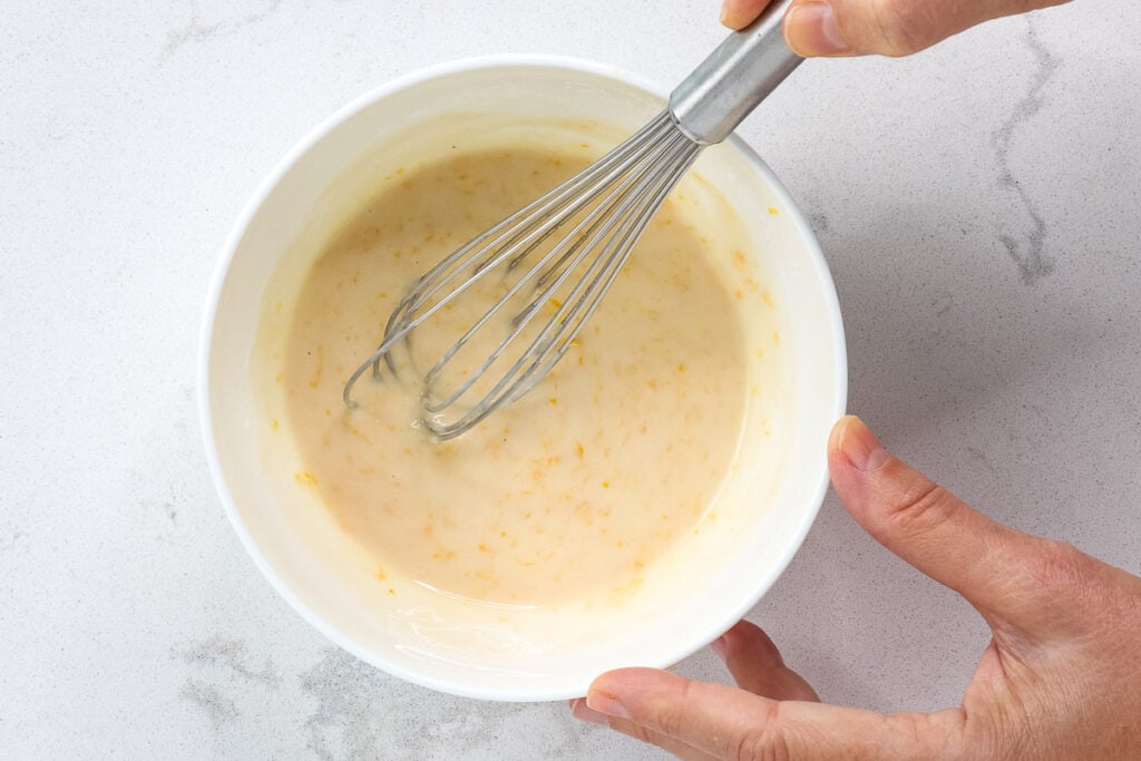 lemon icing in a bowl with whisk. 