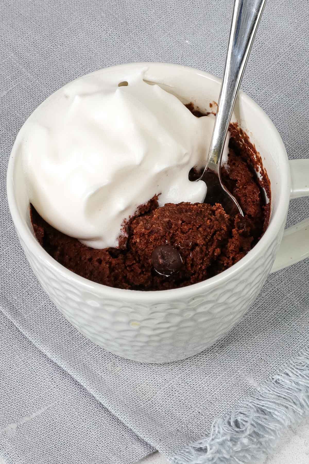 Close up of mug cake with whipped topping.