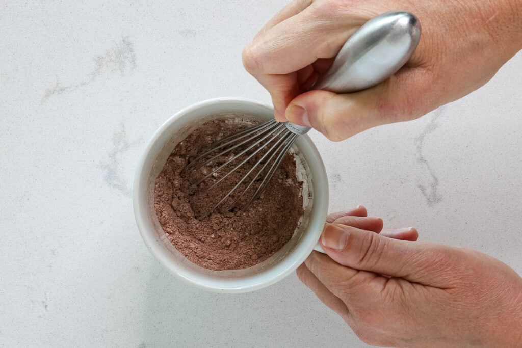 Whisking dry ingredients in a mug.