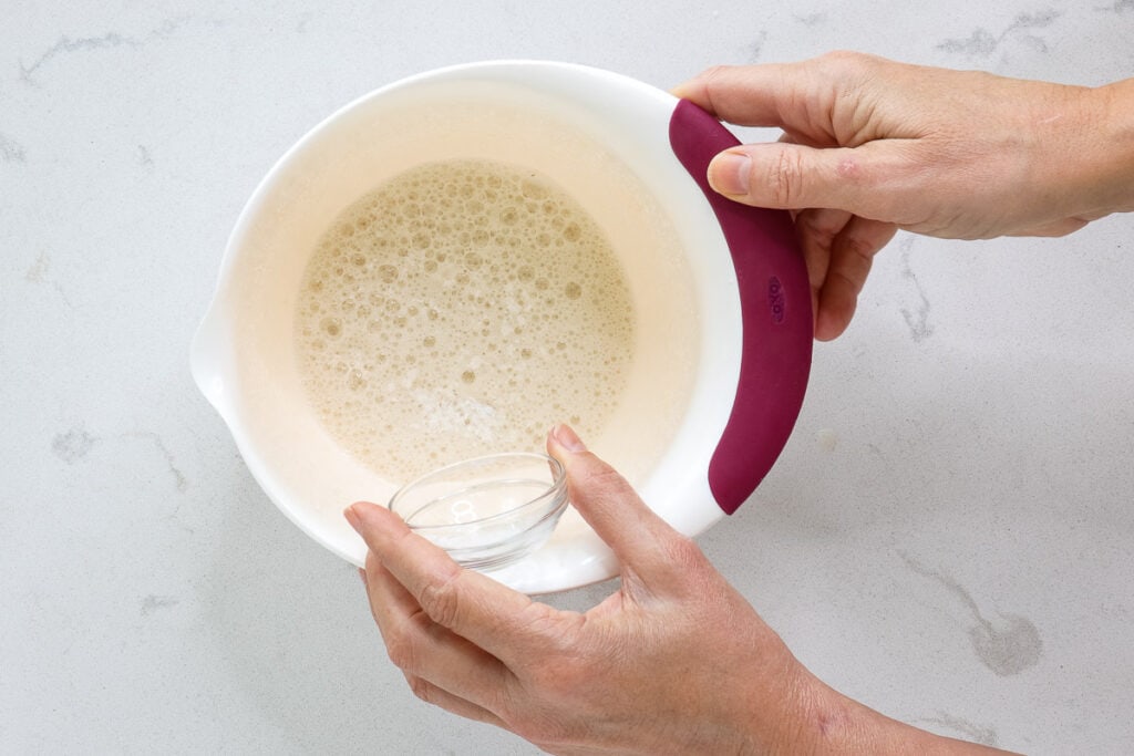 Pouring cream of tarter from glass dish into bowl. 