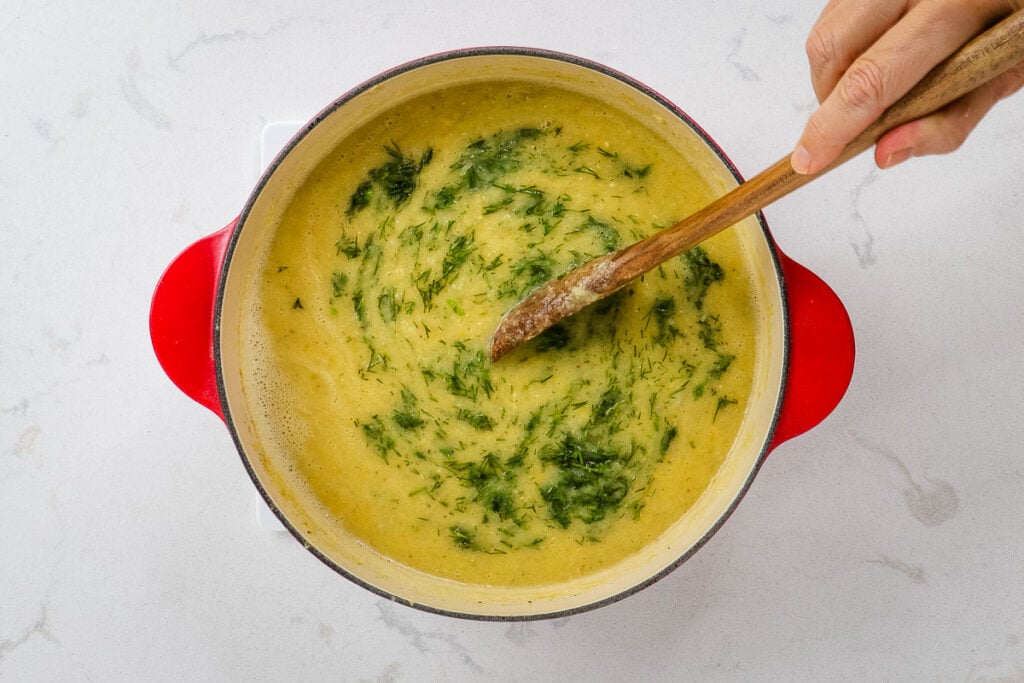 Fresh dill being stirred into the soup.