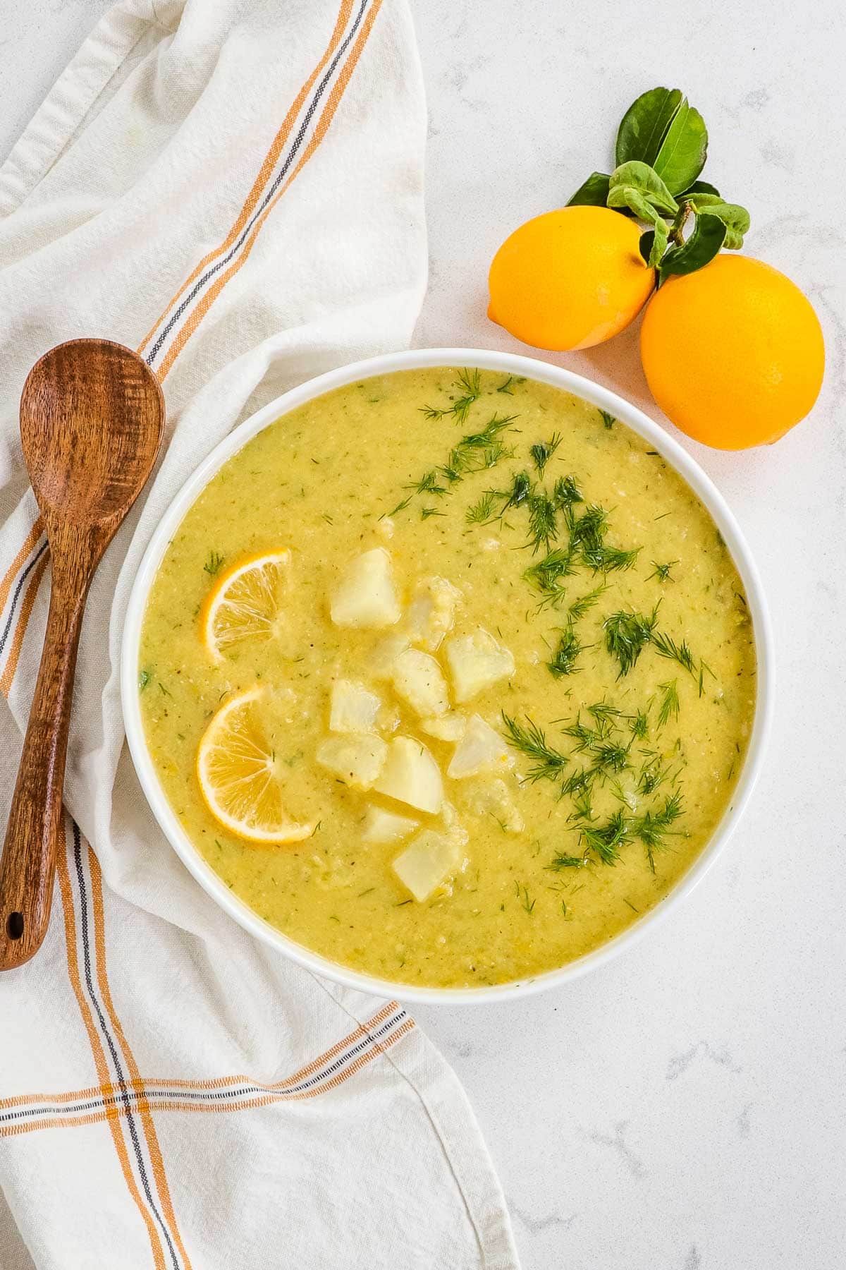 Lemony lentil turnip chowder with wooden spoon and fresh lemons. 